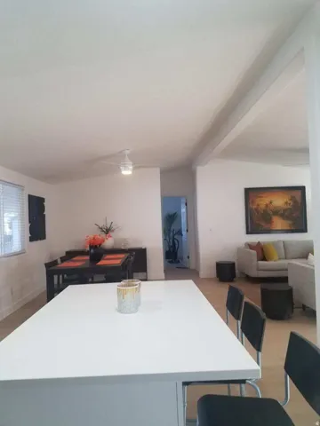 Kitchen featuring a kitchen island, light countertops, a kitchen breakfast bar, open floor plan, and beam ceiling