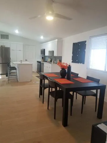 Dining area featuring lofted ceiling, light wood-style flooring, and a ceiling fan