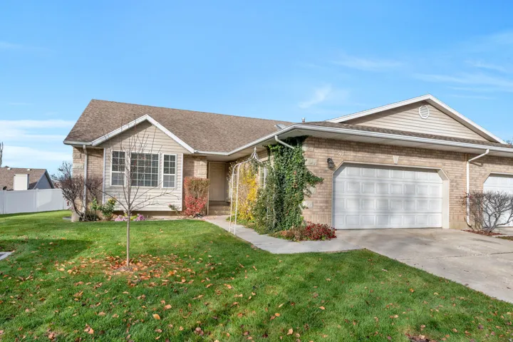 Single story home featuring driveway, an attached garage, brick siding, and roof with shingles