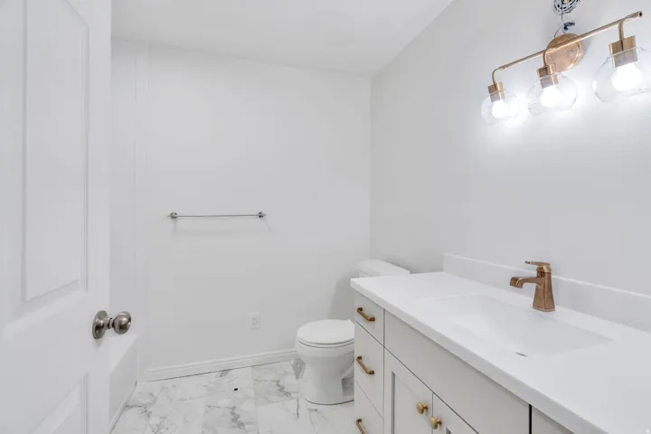 Basement Bathroom with vanity and light marble finish floors