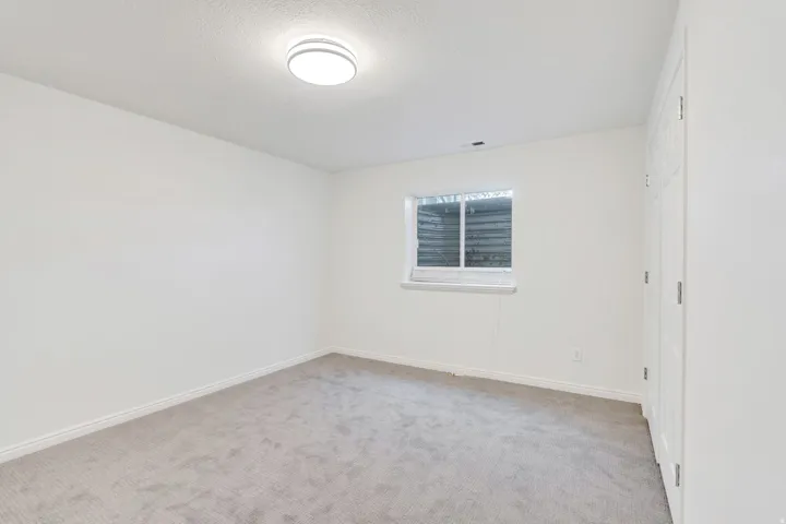 Spare room featuring light carpet and baseboards. Basement Bedroom #2