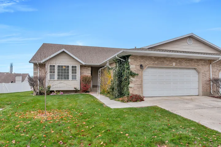 Single story home featuring an attached garage, driveway, brick siding, and a shingled roof