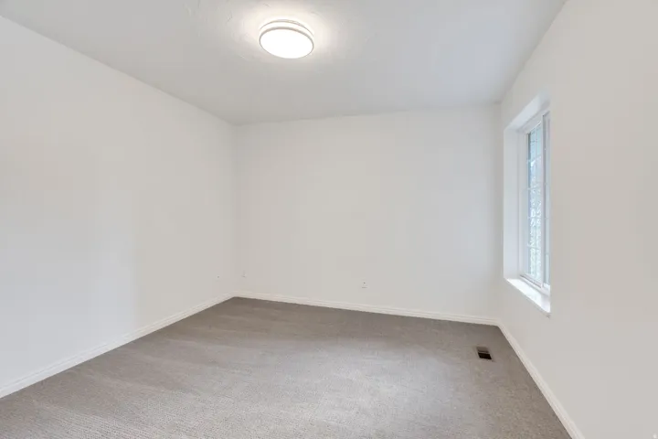 View of second bedroom in main level just off the entryway.
