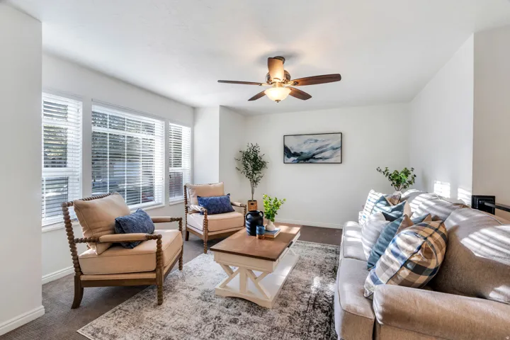 Formal Living area featuring ceiling fan and light carpet