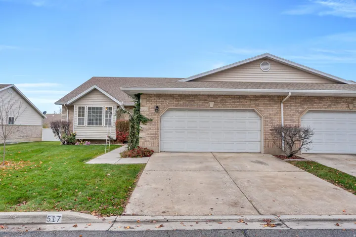 Ranch-style home with roof with shingles, a front lawn, concrete driveway, and brick siding