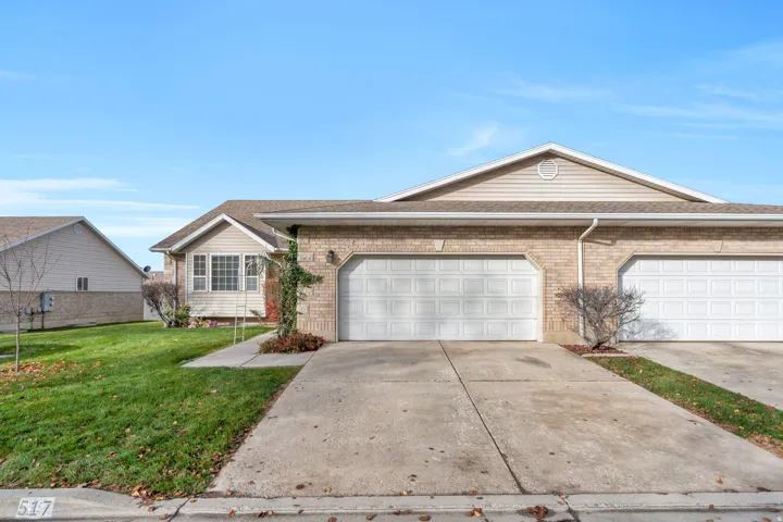 Ranch-style house with concrete driveway, a front lawn, brick siding, and roof with shingles