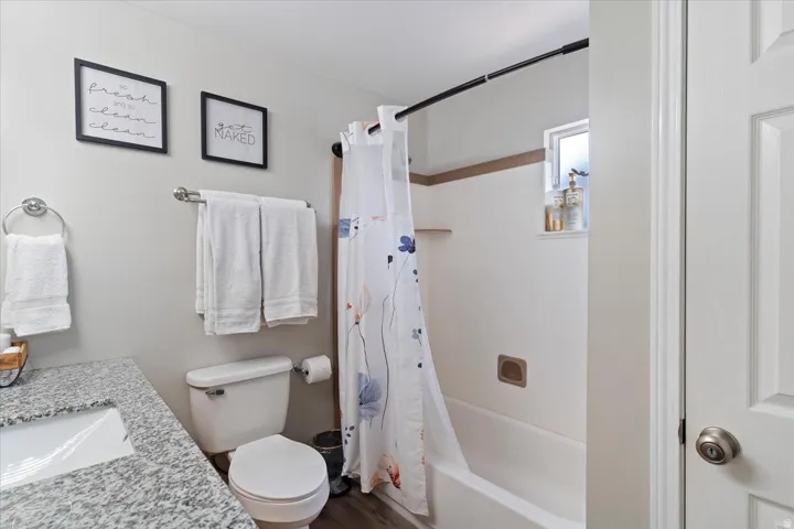Bathroom featuring shower / bathtub combination with curtain and vanity