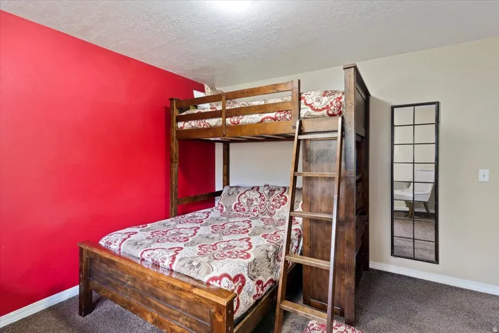 Bedroom featuring carpet and a textured ceiling