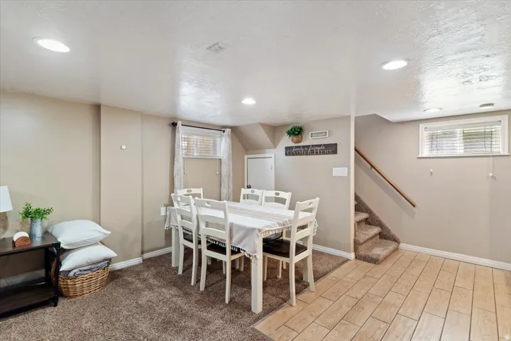 Dining room with tile floors, carpet, a textured ceiling, and recessed lighting