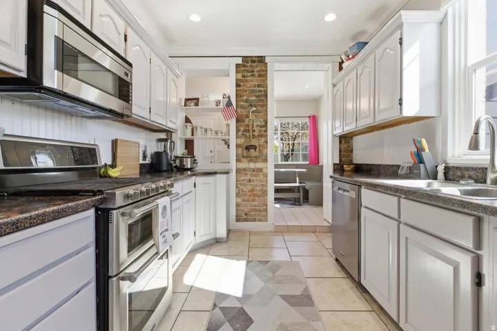 Kitchen featuring stainless steel appliances, white cabinetry, light tile patterned flooring, open shelves, and recessed lighting