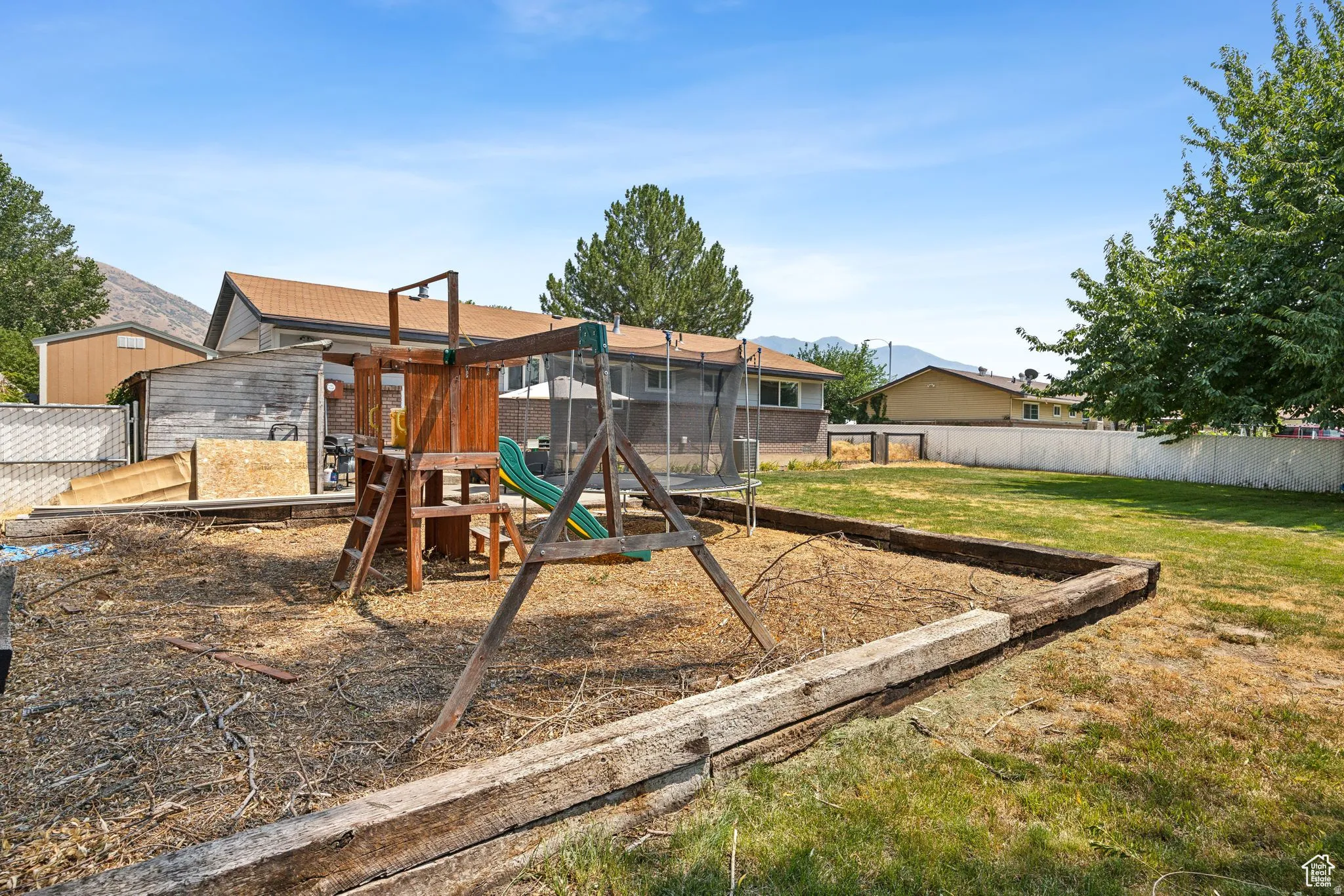 View of playground with a fenced backyard, a mountain view, and a sunroom