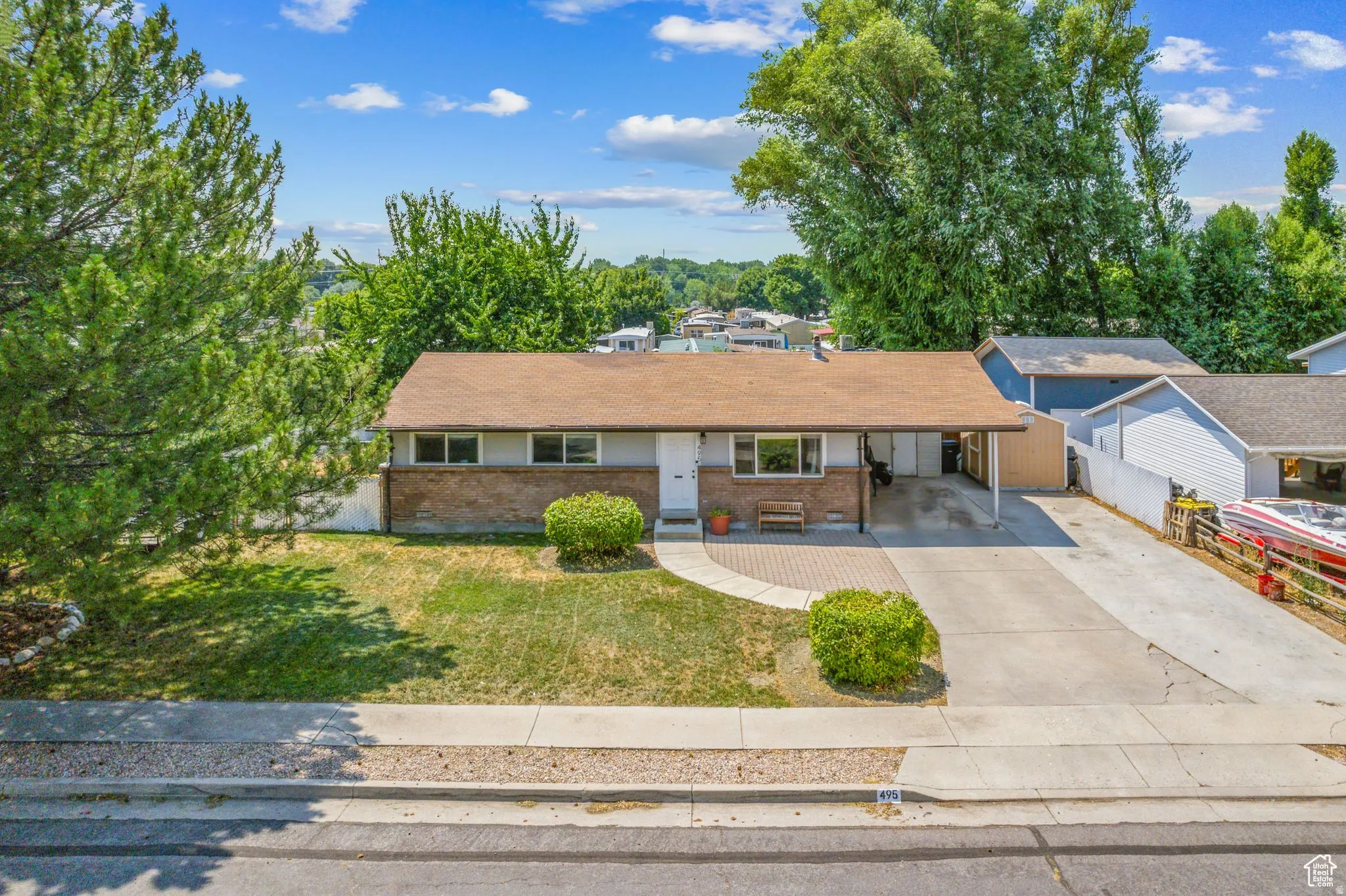 Single story home with brick siding, concrete driveway, and an attached carport