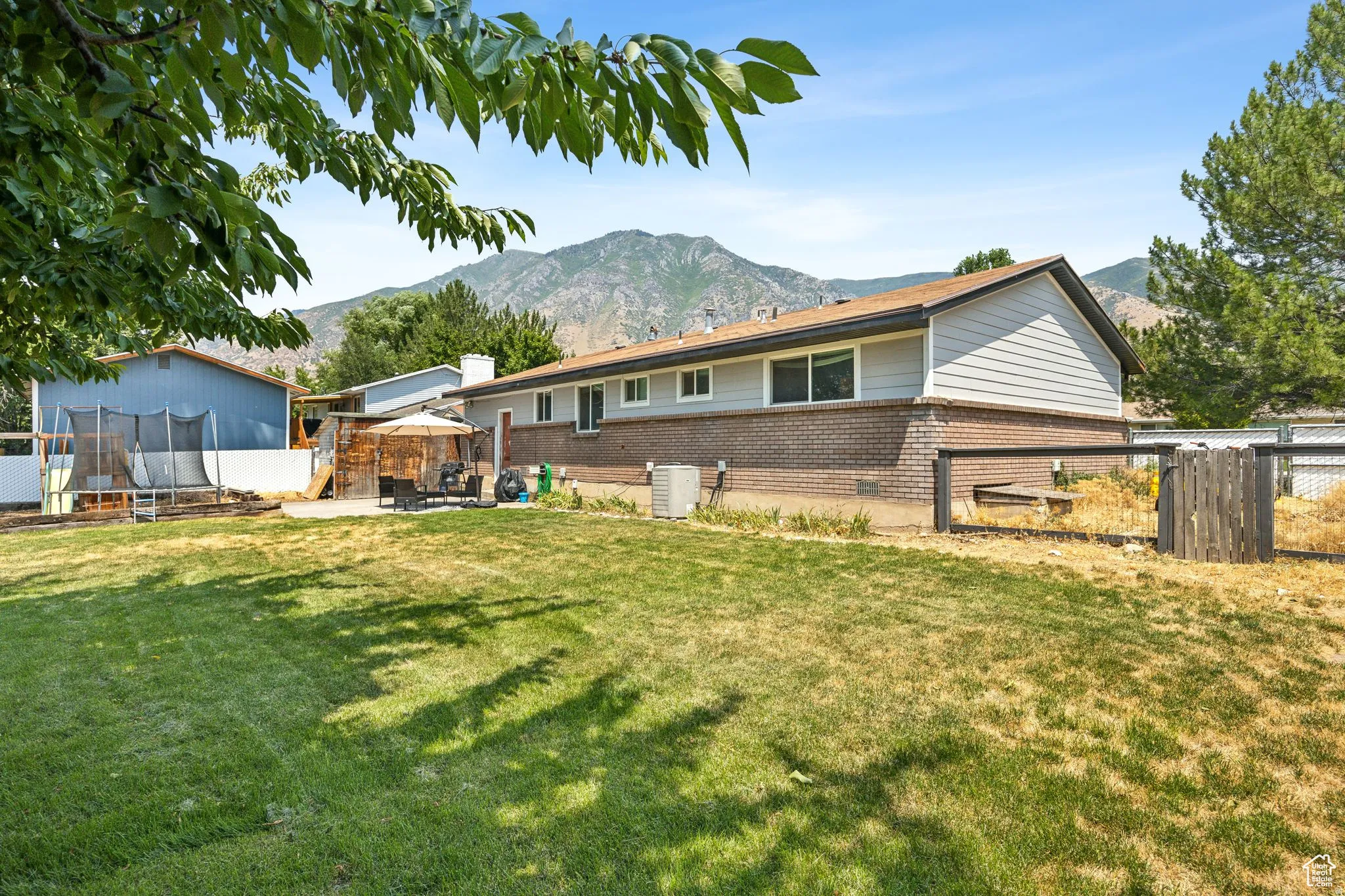 Back of house with brick siding, a gazebo, a mountain view, and a chimney
