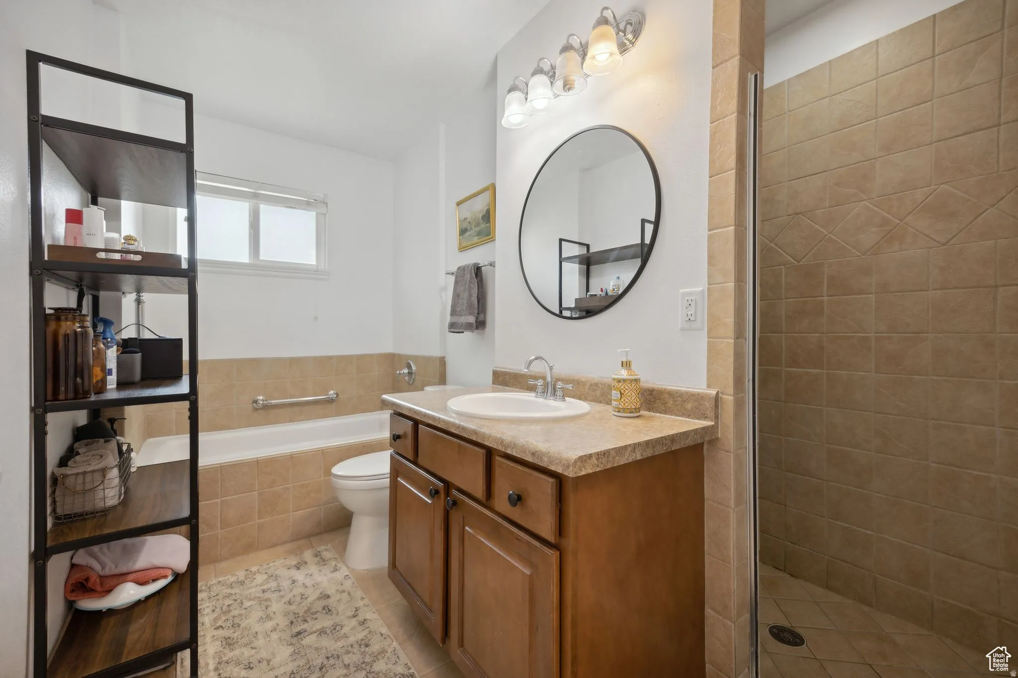 Bathroom with vanity, a shower stall, a garden tub, and light tile patterned floors