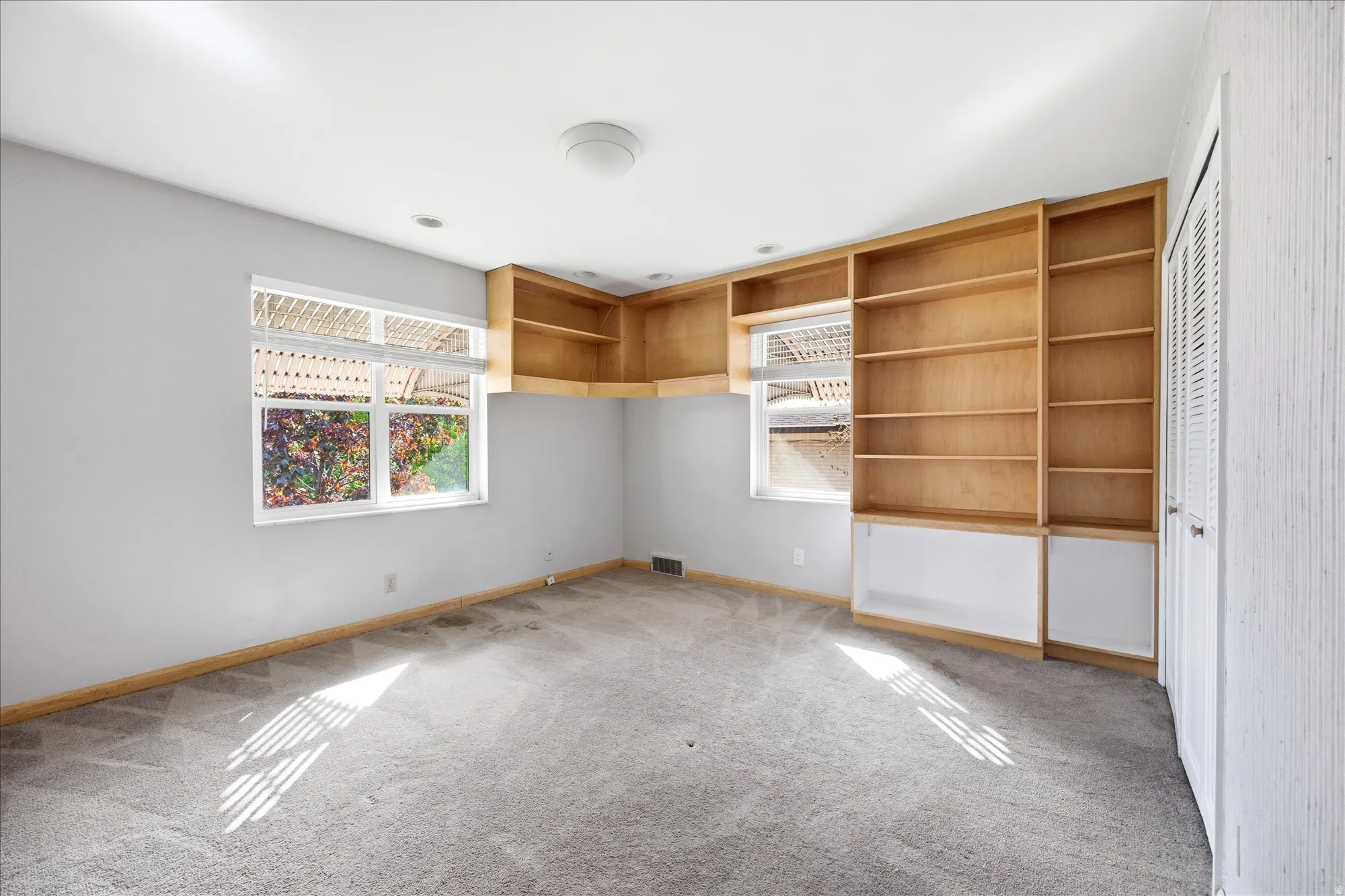 Unfurnished bedroom featuring light carpet and a closet