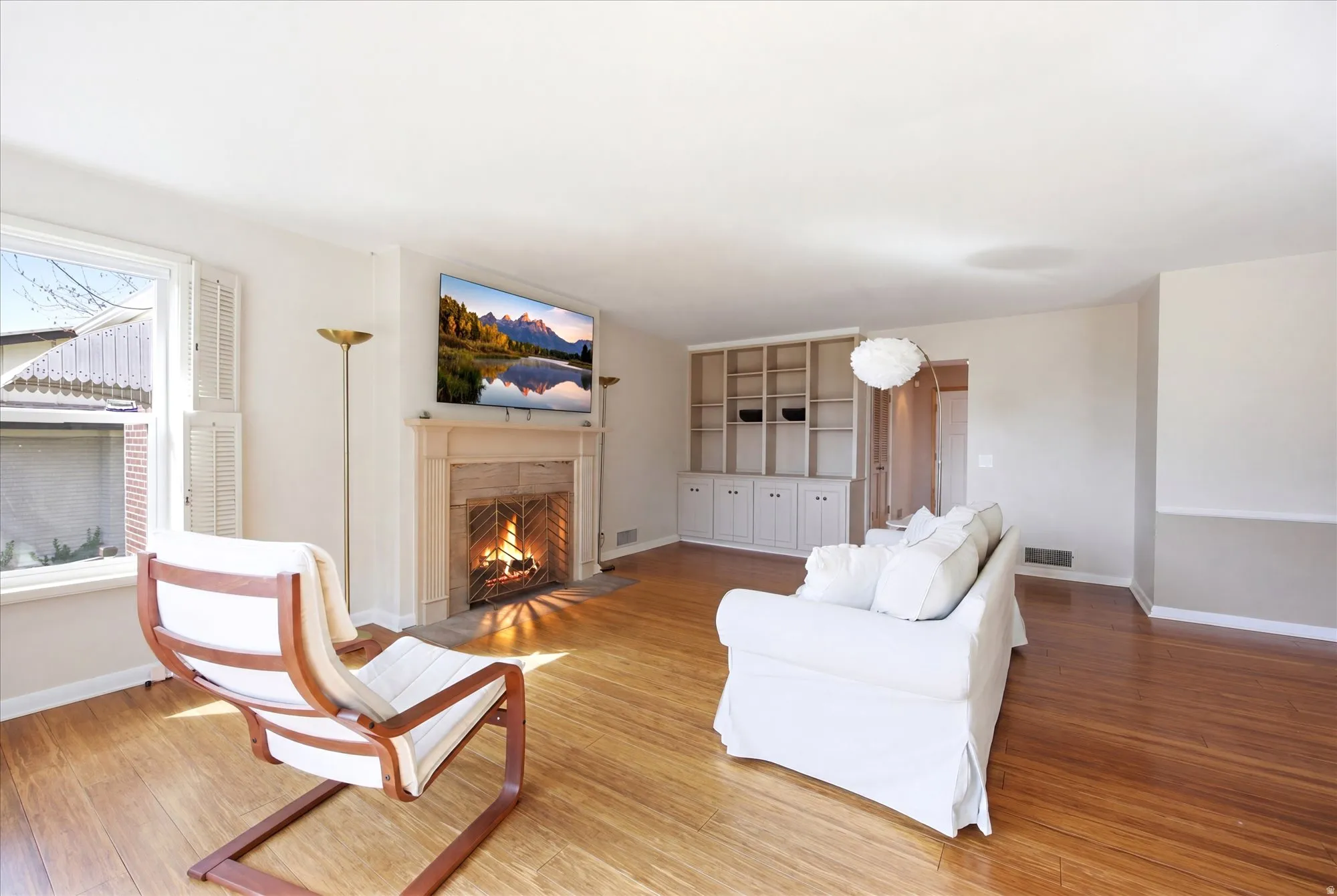 Living room featuring a fireplace with flush hearth and light wood-type flooring