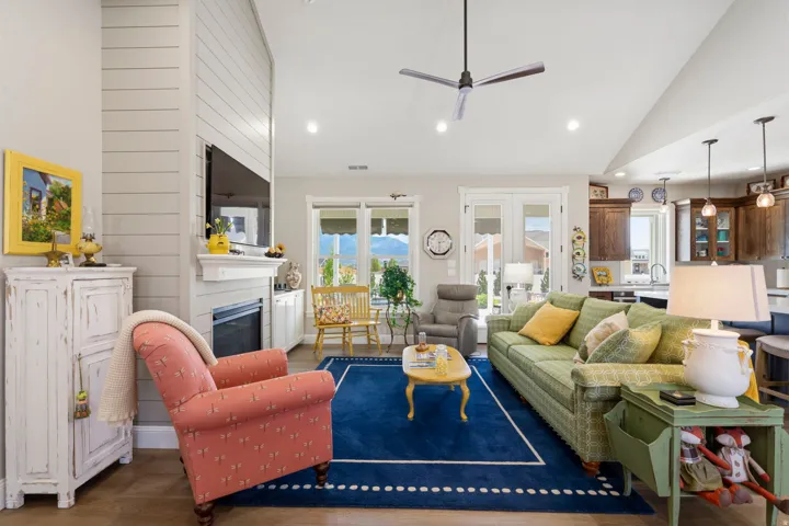 Living room featuring wood finished floors, a ceiling fan, a glass covered fireplace, recessed lighting, and lofted ceiling