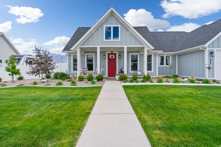 View of front of house featuring board and batten siding, covered porch, and a shingled roof