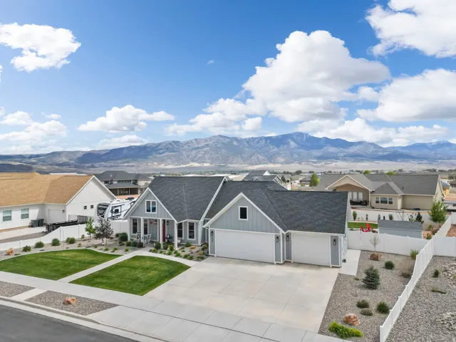 View of front of property featuring a residential view, an attached garage, concrete driveway, and roof with shingles