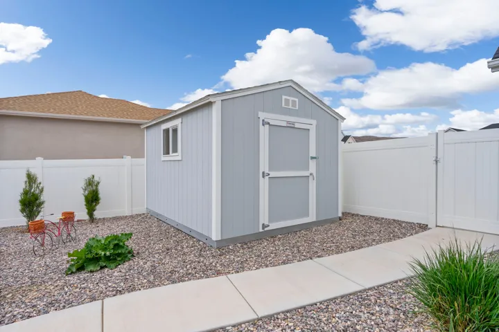 View of shed featuring a fenced backyard and a gate