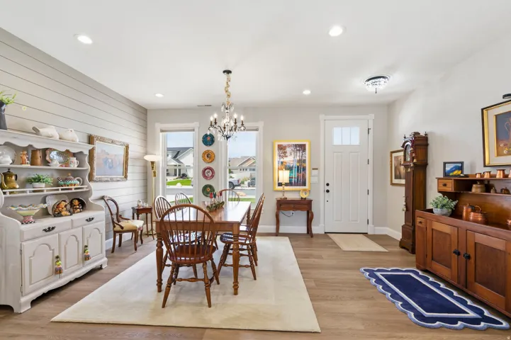 Dining room featuring light wood-type flooring, hanging lights, and wood walls