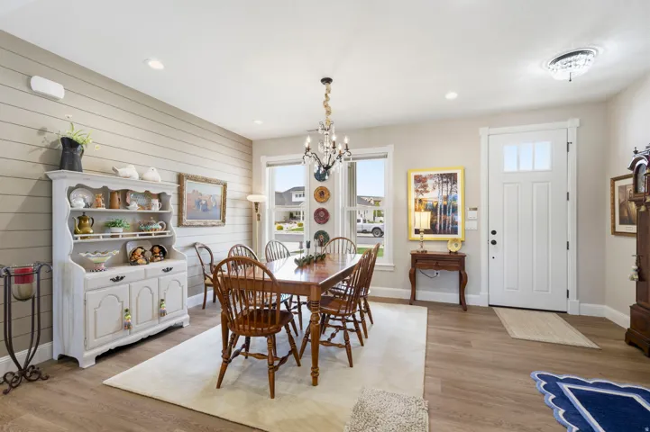 Dining space with light wood-style floors and hanging lights