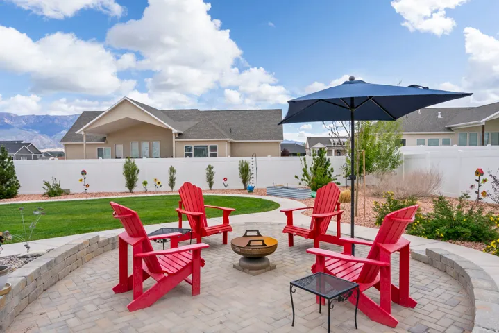 Fenced backyard with an outdoor fire pit, a mountain view, a patio, and a residential view
