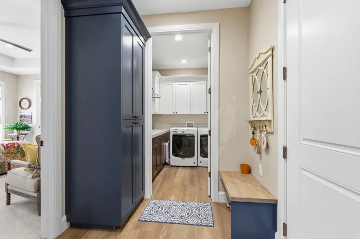 Laundry room featuring separate washer and dryer, light wood-style flooring, cabinet space, and recessed lighting