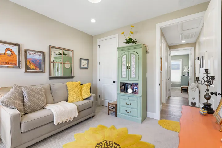 Living area with light colored carpet and recessed lighting