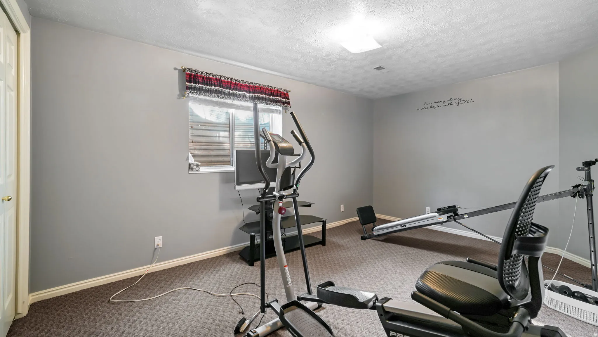 Exercise area with carpet floors and a textured ceiling