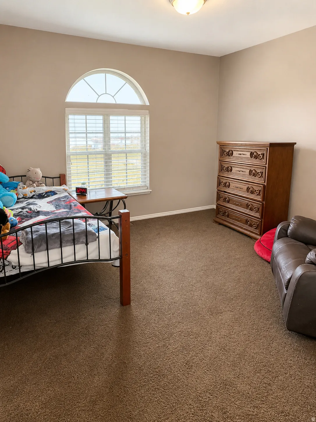 Room with light tan wall paint and brown carpeting