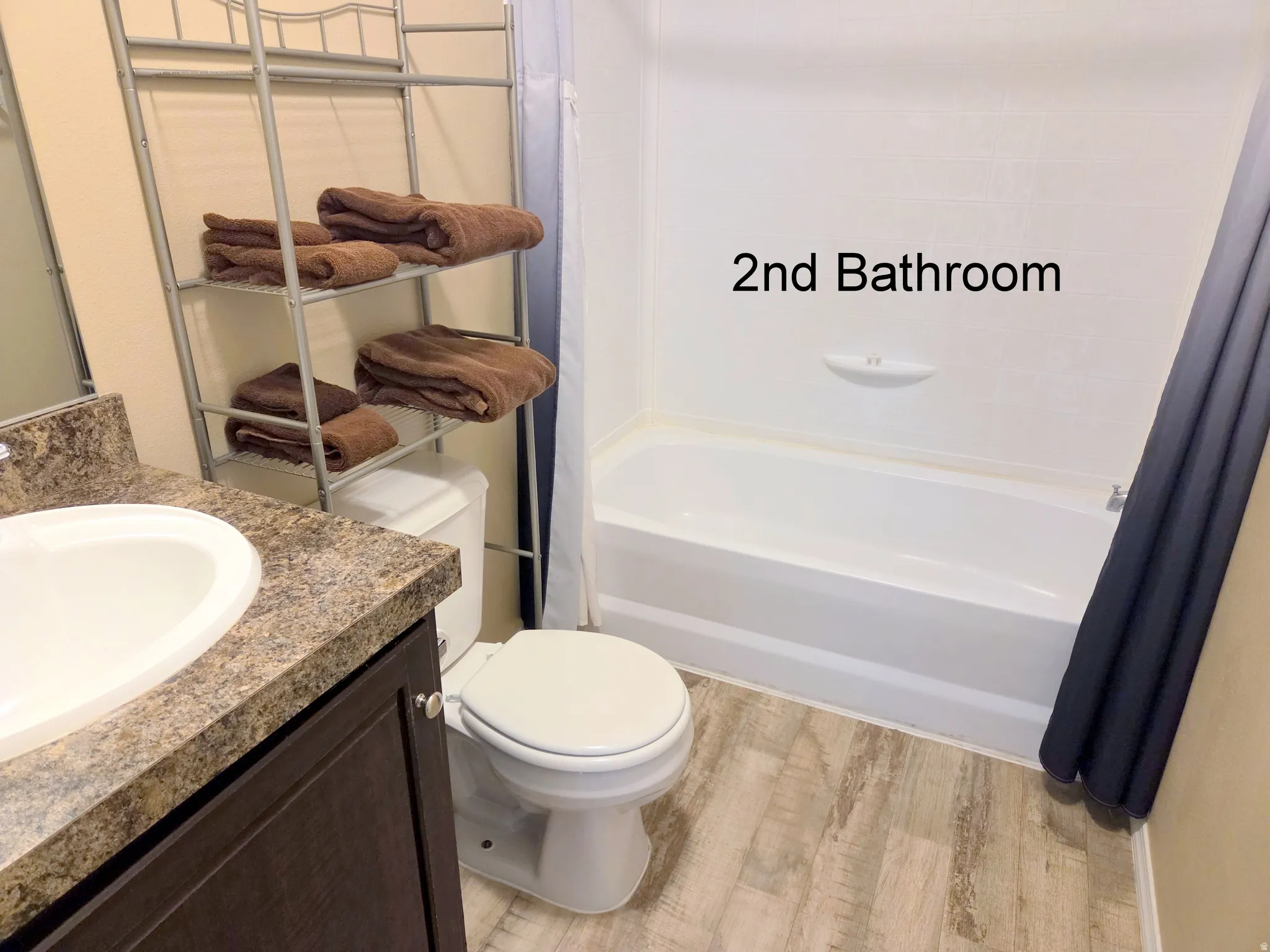 Full bathroom with vanity, light wood-style flooring, and shower / tub combo