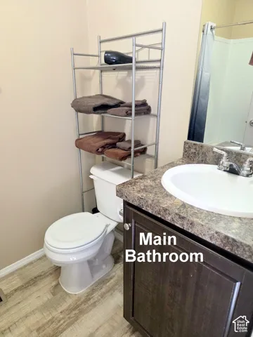 Bathroom featuring a single vanity with a dark wood-finish cabinet and speckled countertop