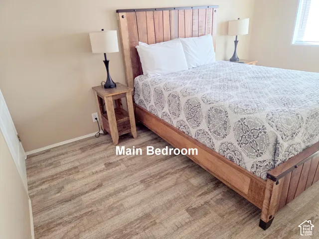Wood-finish flooring throughout, light-toned walls, and a window with horizontal blinds