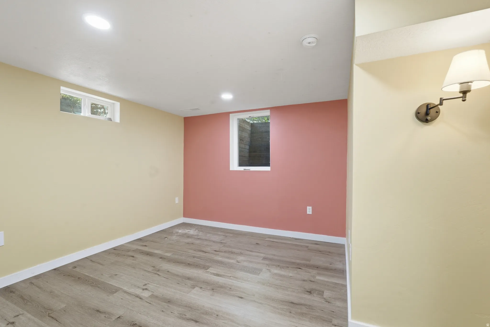 Empty room with light wood-style flooring and recessed lighting