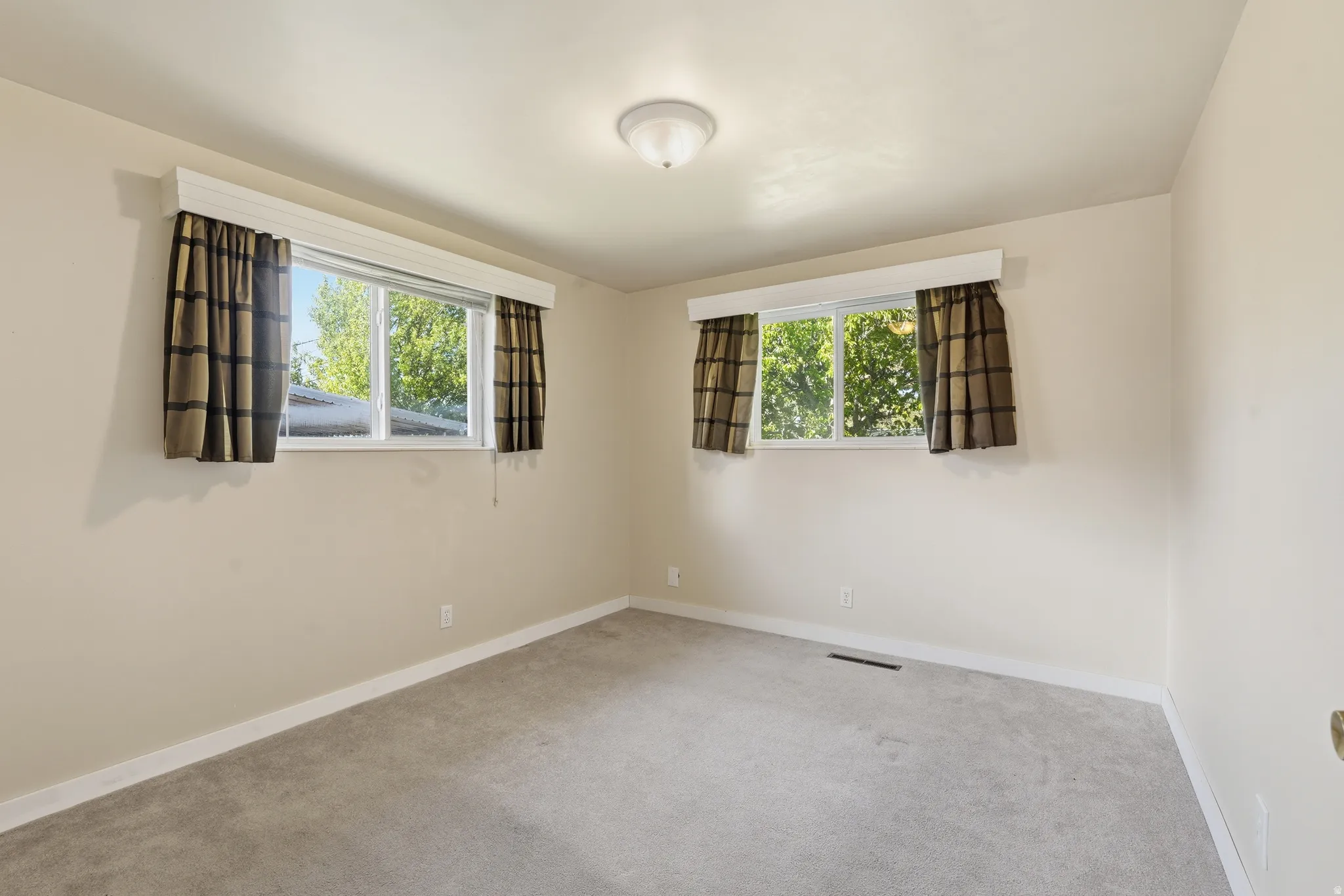 Carpeted spare room featuring plenty of natural light
