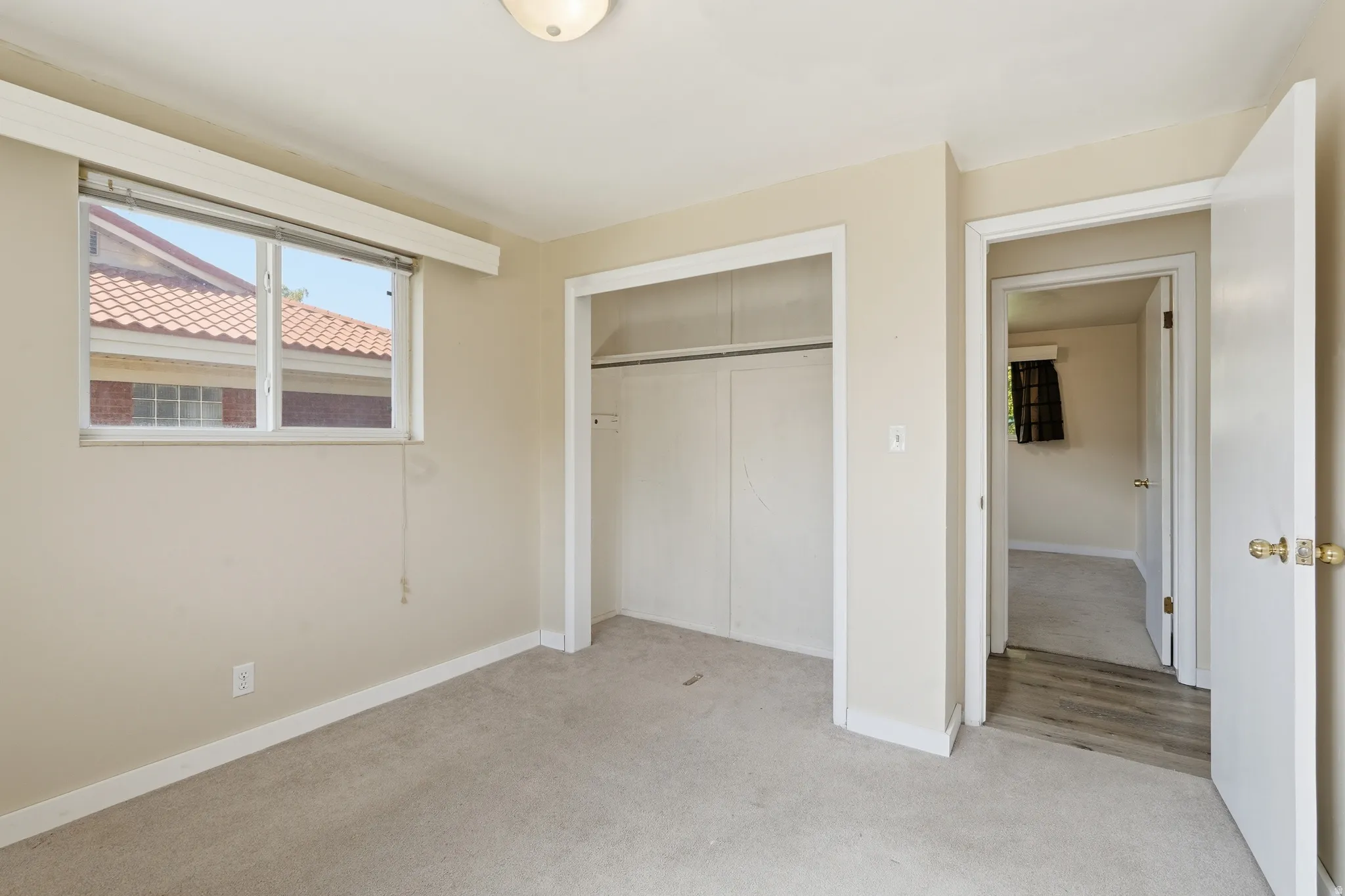 Unfurnished bedroom featuring light carpet and a closet