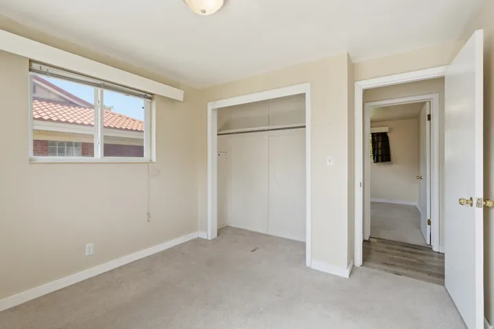 Unfurnished bedroom featuring light carpet and a closet