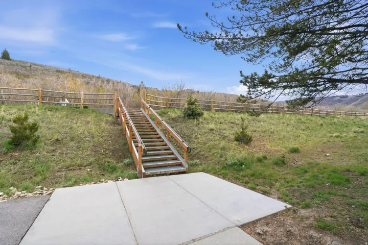 Fenced backyard featuring a rural view and stairway