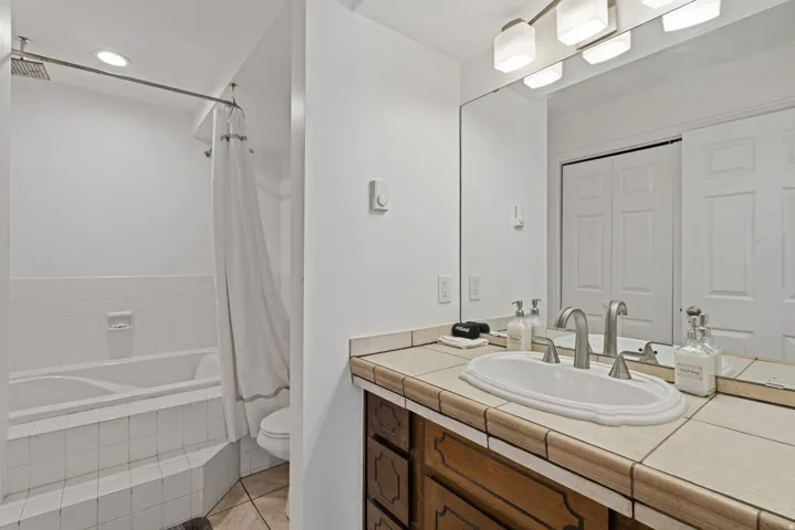 Full bath featuring vanity, tiled shower / bath, and light tile patterned floors