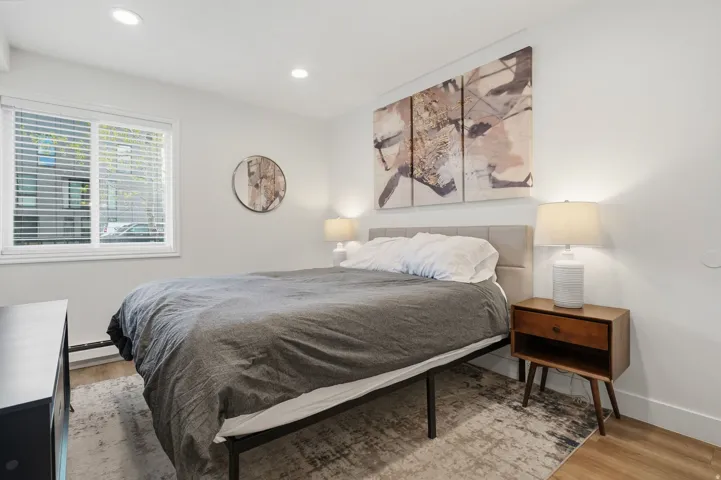 Bedroom with light wood-style floors, recessed lighting, and a baseboard heating unit