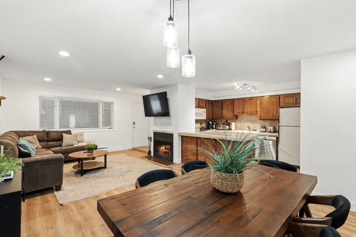 Dining space featuring a fireplace with flush hearth, light wood-style floors, and recessed lighting