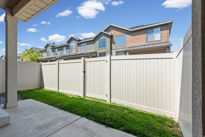 Private backyard patio with a concrete surface and a manicured lawn