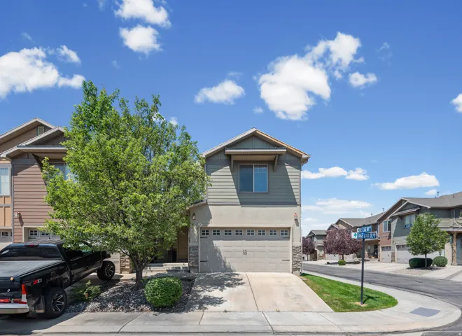 Two-story residence featuring a neutral-toned exterior with siding and stone accents