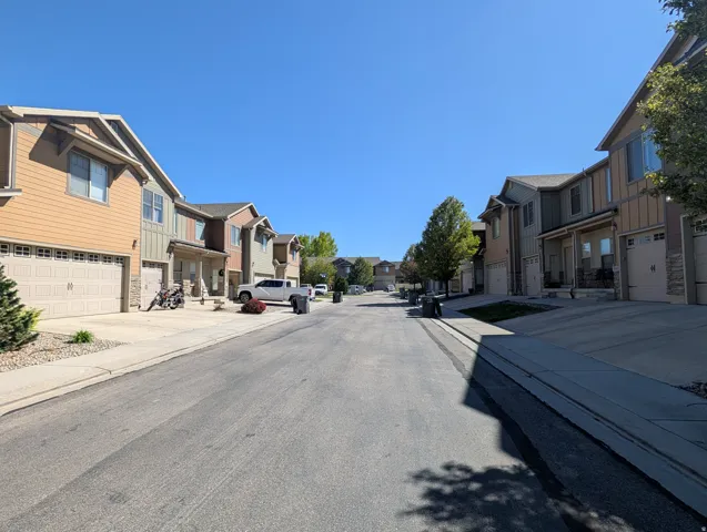 View of asphalt street with sidewalks, a residential view, and curbs
