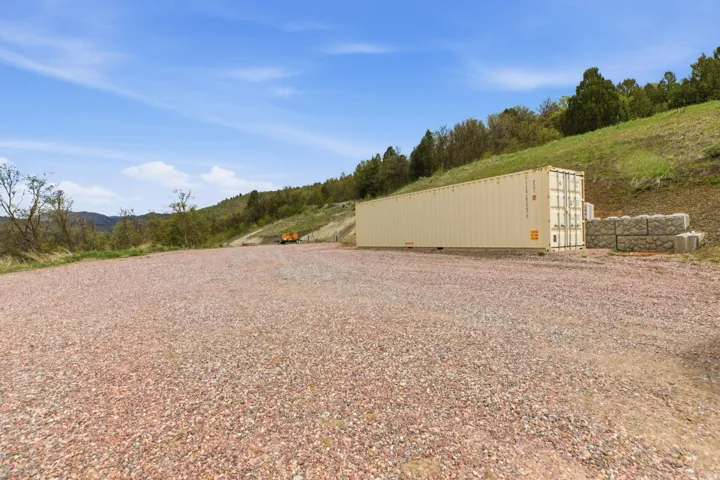 View of yard- storage shed-graveled area