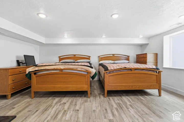 Bedroom with light wood-style flooring and a textured ceiling