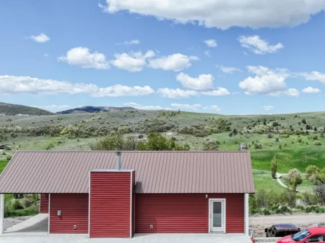 Exterior space featuring a mountain view, a metal roof, and faux log siding