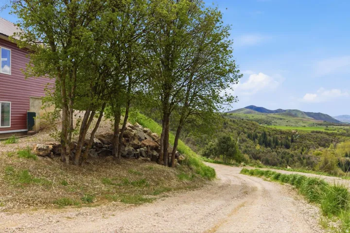 View of dirt / gravel road with a mountain viewn-drive way coming up to house