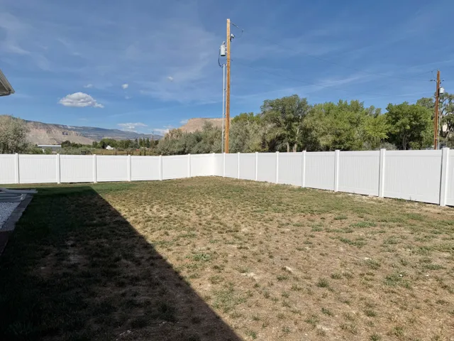 Expansive backyard with a full privacy fence and mountain backdrop